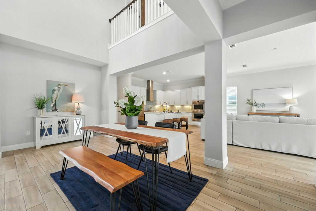 Bright open-concept dining and living space with coastal kitchen and natural wood accents